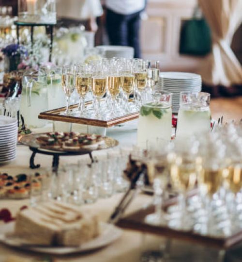 stylish champagne glasses and food  appetizers on table at wedding reception. luxury catering at celebrations. serving food and drinks at events concept